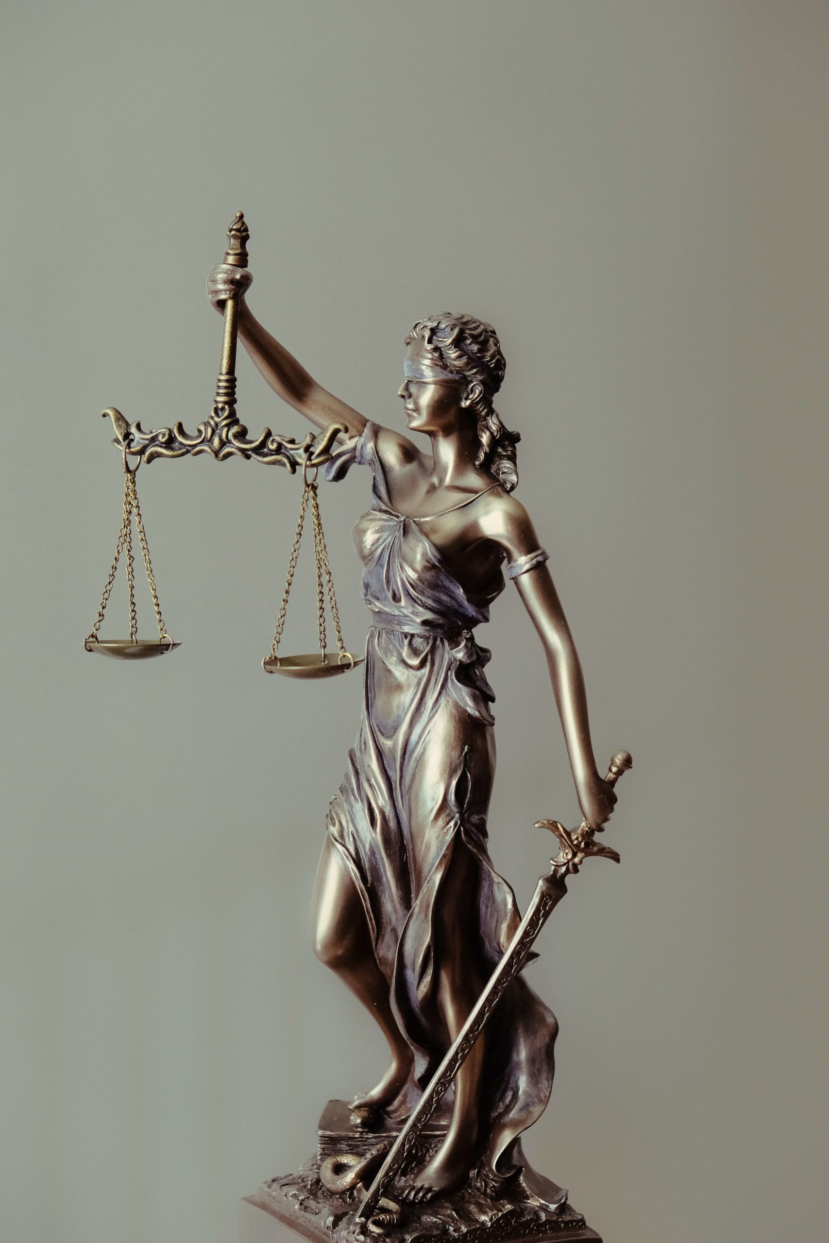 brass figurine holding scales of justice