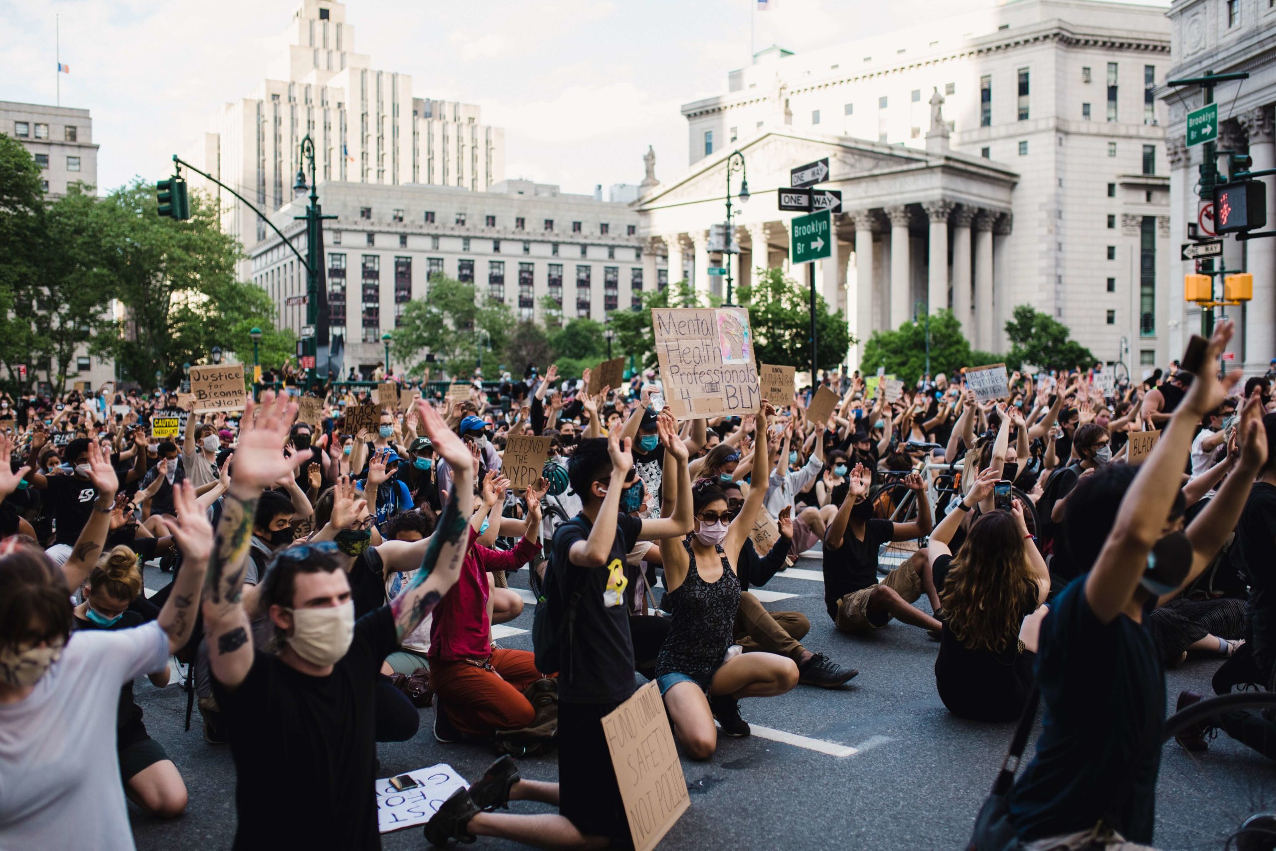 protestors kneeling with masks on at a protest